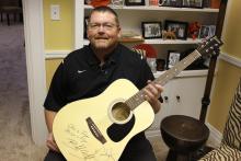 Coach McCarty with a guitar signed by Blake Shelton and Miranda Lambert