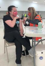ECU Nursing professor Dr. Liz Massey, right, administers a vaccination to Nursing student Megan Jernigen in advance of opening the Pontotoc County Agri-Plex for public vaccinations.