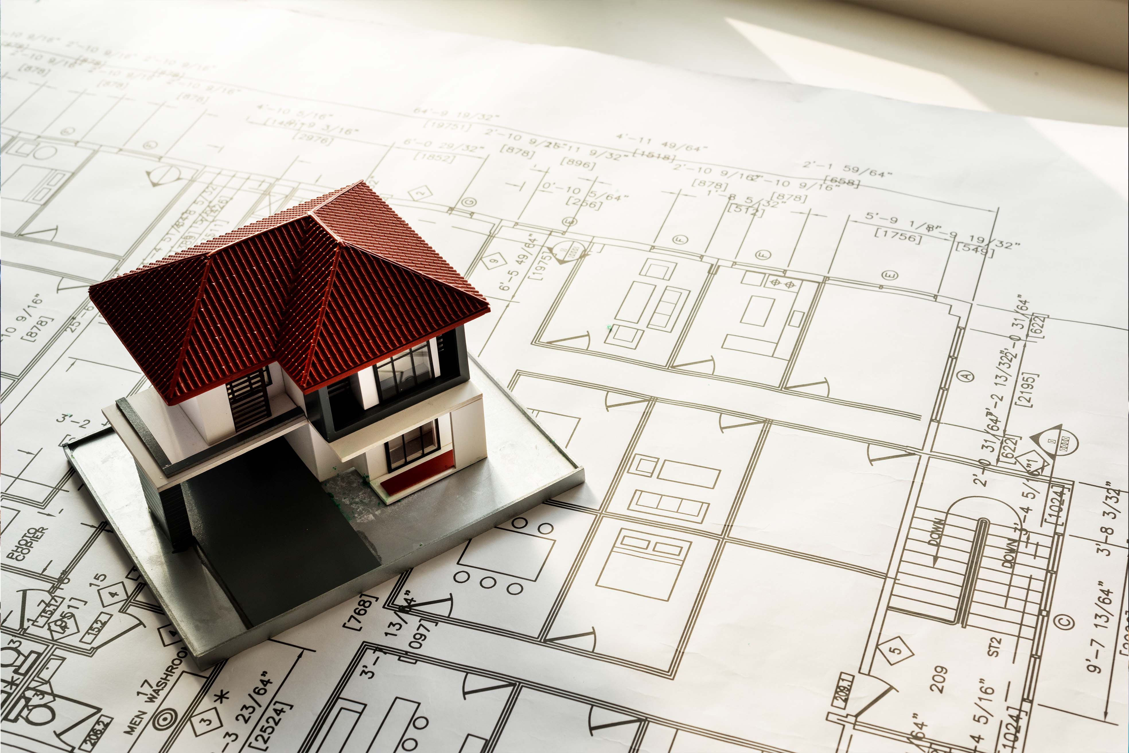 model of a house sitting on blueprints