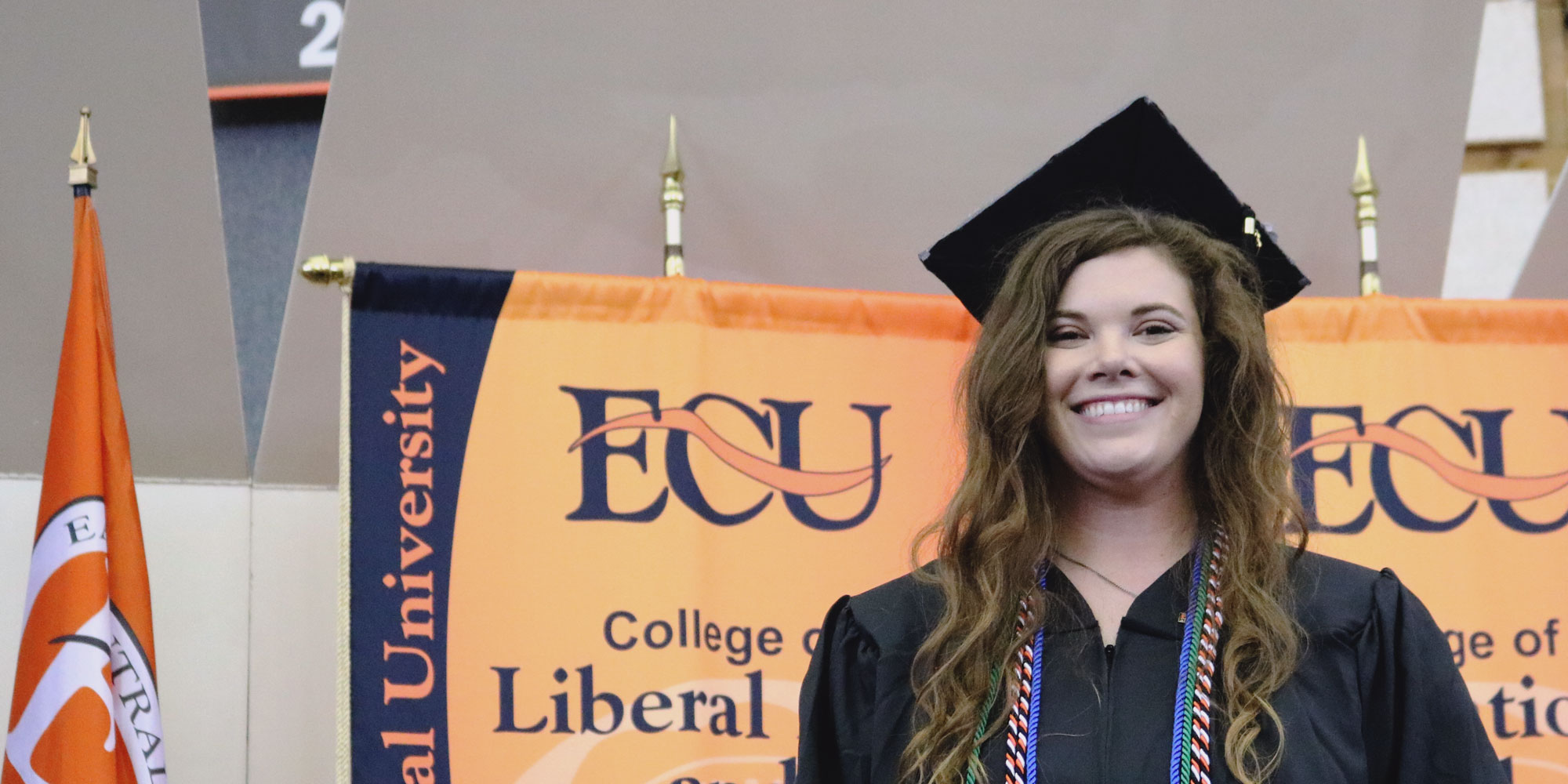 graduated woman standing in front of flags