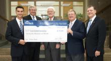 endell Godwin (left), dean of the School of Business at East Central University, and Jim Hamby (second from right), CEO of Vision Bank, hold a $25,000 check, part of the bank’s $100,000 gift to ECU for the construction of a new business and conference center.