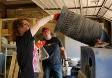 East Central University Art major T.J. Norman grinds glass bottles while Dr. Christine Pappas supervises their work.