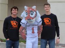 Two students pose for the camera with a Roary mascot cardboard cutout at East Central University